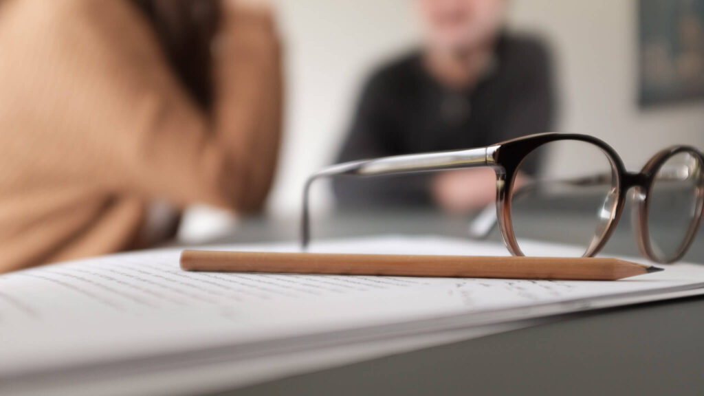 Brille und Bleistift liegen auf einem Block